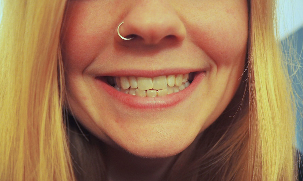 A close up photo of the lower half of Steph Jones' face with a large smiling grin